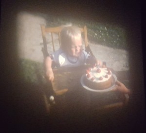 Photo of film of George aged 1 plucking strawberries from his birthday cake